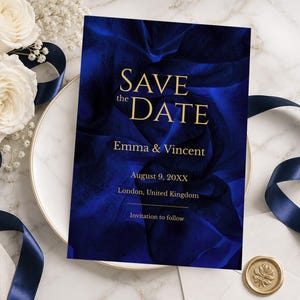 May include: A navy blue Save the Date card with gold lettering, featuring the names Emma & Vincent, date, and location. The card is set against a dark blue floral background, with white roses and a navy ribbon. A gold wax seal is also present.