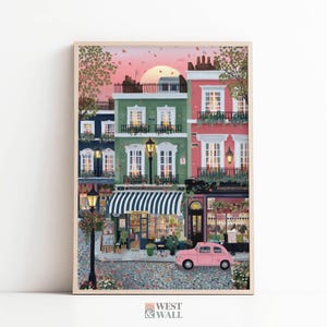 May include: A vertical art print depicting a European-style street scene at sunset with a pink sky. The illustration features multi-story buildings in green, red, and dark blue, a striped shop awning, street lamps, and a small pink car parked in front.