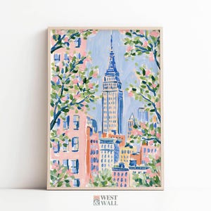 May include: A vertical art print featuring a painterly depiction of a city skyline with a prominent blue skyscraper at the center. The scene is framed by branches with green leaves and pink blossoms against a light blue sky and peach buildings.