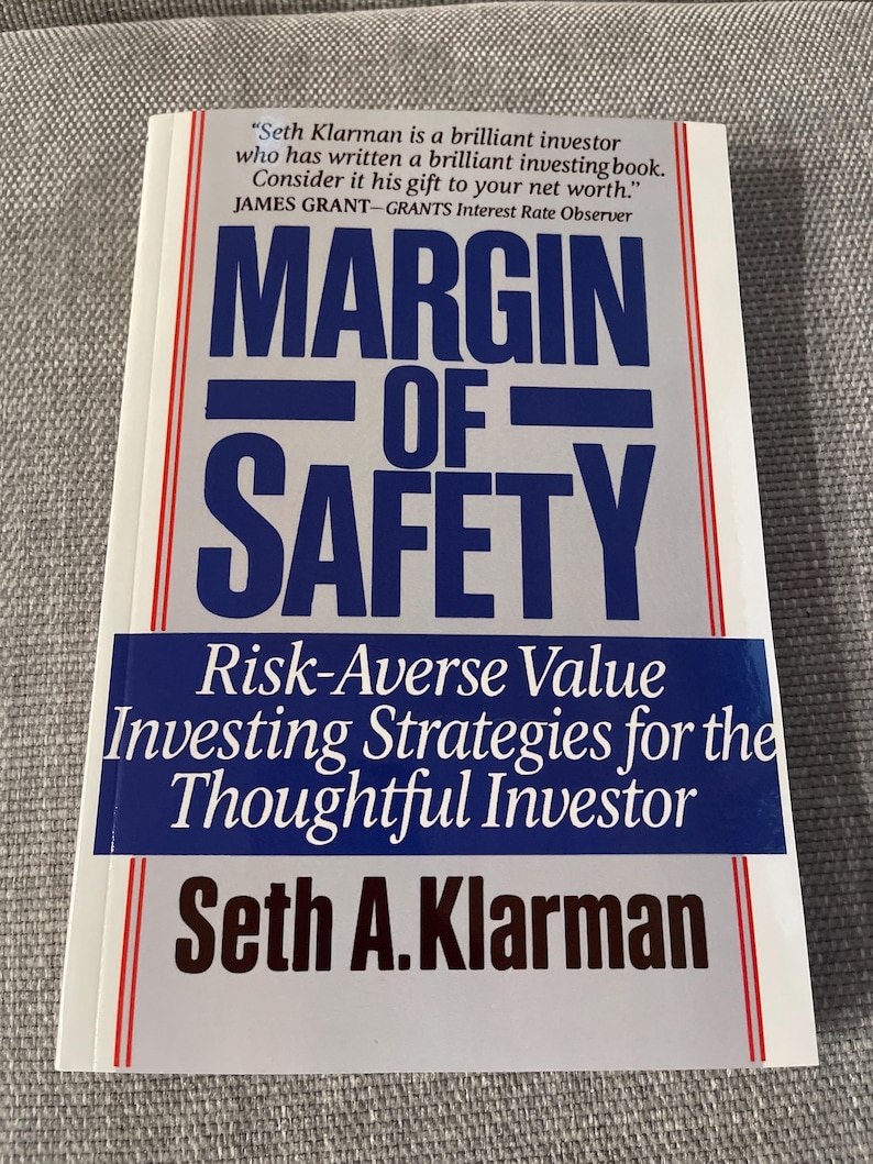 Puede incluir: Un libro de tapa dura titulado "Margin of Safety" de Seth A. Klarman. La portada presenta el t&iacute;tulo en letras azules grandes, con el subt&iacute;tulo "Risk-Averse Value Investing Strategies for the Thoughtful Investor". Tambi&eacute;n es visible una cita de James Grant.
