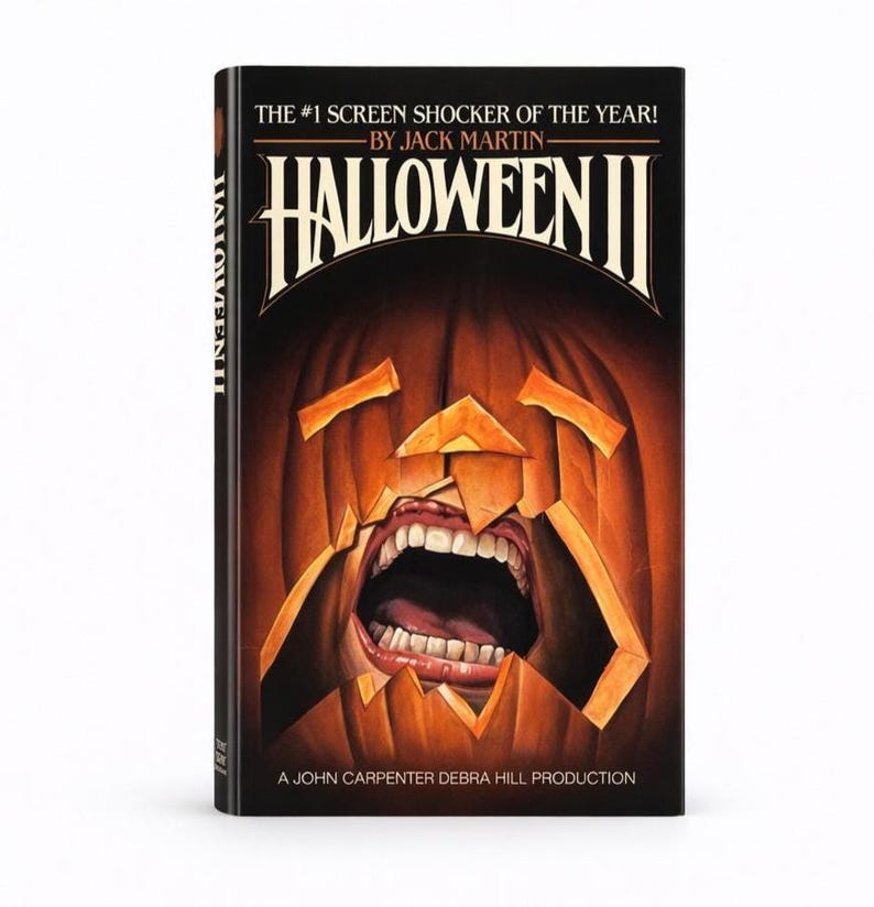 Pu&ograve; includere: Copertina del libro "Halloween II" con una zucca intagliata con la bocca aperta e i denti. Il titolo &egrave; in lettere bianche in grassetto su sfondo nero. Il testo "THE #1 SCREEN SHOCKER OF THE YEAR!" &egrave; sopra il titolo.
