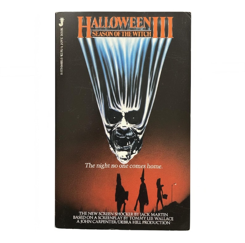 May include: A vintage VHS tape for "Halloween III: Season of the Witch." The cover features a menacing skull-like face with a white and blue light effect against a dark background. Text includes the title, tagline, and production credits.