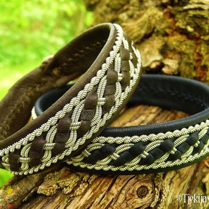 May include: Two leather bracelets with silver braided trim. The bracelet on the left is brown leather and the bracelet on the right is black leather.