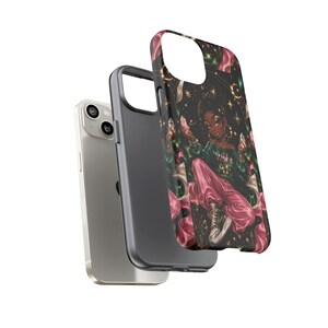 May include: A silver smartphone and two protective cases. One case is solid dark gray, while the other features a black background with a graphic illustration of a person in a green shirt and pink pants surrounded by gold stars and crystals.