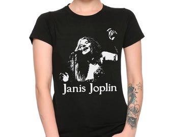 May include: Black t-shirt featuring a white graphic of Janis Joplin singing, with her name printed below. The image is a stylized, high-contrast design. The shirt is a classic crew neck style.