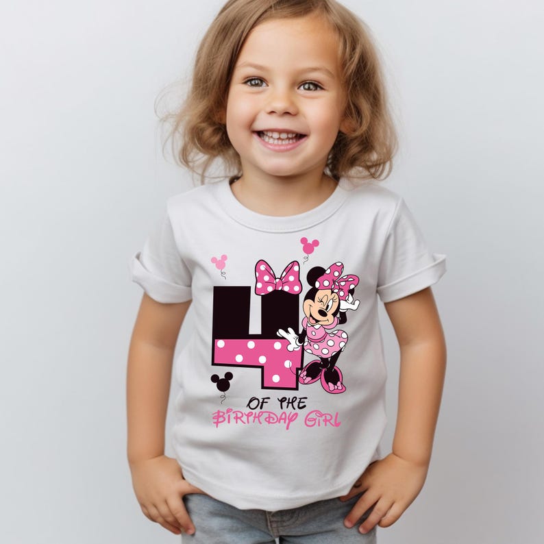 K&ouml;nnte beinhalten: Wei&szlig;es T-Shirt mit einem Minnie-Mouse-Design, das die Zahl 4 in Schwarz und rosa Punkten zeigt. Der Text "OF THE BIRTHDAY GIRL" steht unter der Zahl. Das T-Shirt hat kurze &Auml;rmel und wird von einem jungen Kind getragen.