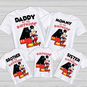 May include: White t-shirts featuring Mickey Mouse designs. Each shirt displays a large number 4, Mickey Mouse, and the word "Boy". The shirts also read "Daddy of the Birthday", "Mommy of the Birthday", "Brother of the Birthday", "Birthday", and "Sister of the Birthday".