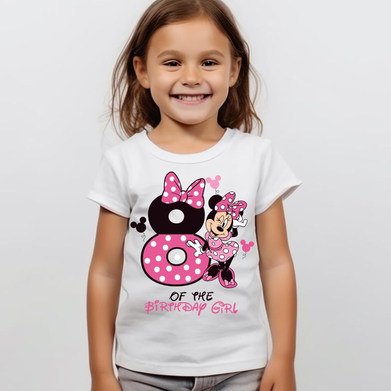 K&ouml;nnte beinhalten: Wei&szlig;es T-Shirt mit einem Minnie Mouse-Motiv. Das Design umfasst eine gro&szlig;e, rosa gepunktete Zahl 8, Minnie Mouse und den Text "OF THE BIRTHDAY GIRL". Das T-Shirt ist f&uuml;r ein Kind.