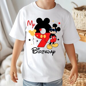 May include: White t-shirt featuring a colorful Mickey Mouse design for a ninth birthday. The design includes the number 9 in red, Mickey Mouse, the words "My Birthday", and star and balloon graphics.