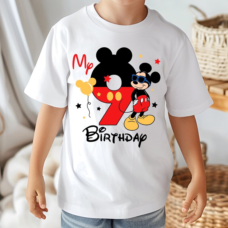 May include: White t-shirt featuring a colorful Mickey Mouse design for a ninth birthday. The design includes the number 9 in red, Mickey Mouse, the words "My Birthday", and star and balloon graphics.