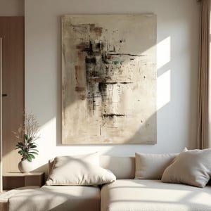 May include: Large abstract painting with beige, brown, and black brushstrokes. The artwork hangs above a beige sectional sofa with matching pillows. The room has a neutral color palette with natural light.