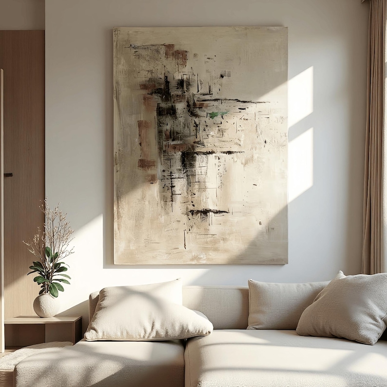 May include: Large abstract painting with beige, brown, and black brushstrokes. The artwork hangs above a beige sectional sofa with matching pillows. The room has a neutral color palette with natural light.