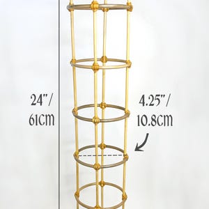May include: A bamboo plant support structure, 61cm tall and 10.8cm wide. The support has a cylindrical shape with horizontal rings and vertical supports, suitable for climbing plants.