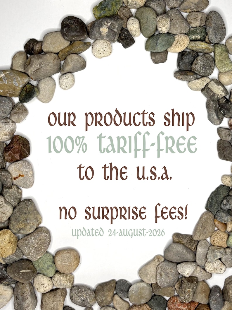 May include: A circular arrangement of smooth, multi-colored river stones surrounding text that reads: Our products ship 100% tariff-free to the U.S.A. No surprise fees! Updated 24-August-2026. The stones are various shades of gray, brown, and tan.