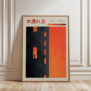 Peut inclure: Une affiche encadrée avec un design minimaliste. L'œuvre représente un bâtiment sombre avec des fenêtres éclairées en orange sur un fond orange. L'impression comprend du texte japonais et les mots "1974 TOKYO".