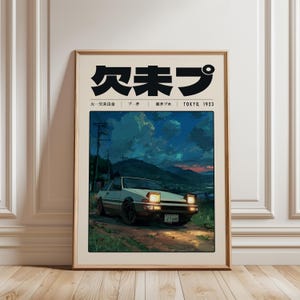 May include: A framed art print depicting a white car with pop-up headlights on a dirt track, set against a night sky and mountains. The top of the print has Japanese text and the words "TOKYO 1923". The artwork is in a wooden frame.