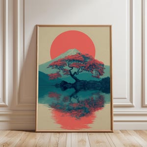 May include: Framed art print featuring a Japanese landscape. A red sun sets behind a mountain and a tree with red leaves. The tree is reflected in the water below, creating a symmetrical image. The color palette includes red, teal, and beige.