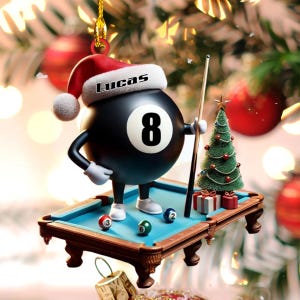 Può includere: Un ornamento sospeso raffigurante un personaggio a forma di palla 8 nera che indossa un cappello da Babbo Natale rosso e bianco con il nome Lucas stampato sul bordo. Il personaggio è su un tavolo da biliardo in miniatura con tre biglie.