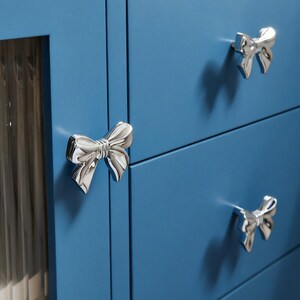 Pomello per cassetto a forma di fiocco in ottone argentato: un tocco di originalità per la maniglia del mobile.