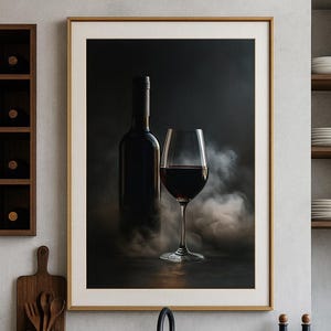 Könnte beinhalten: Gerahmter Kunstdruck mit einer Weinflasche und einem Glas Rotwein. Das Bild hat eine dunkle, stimmungsvolle Ästhetik mit Rauchschwaden. Die Szene spielt auf einer Küchenarbeitsplatte mit einem schwarzen Waschbecken und Wasserhahn.