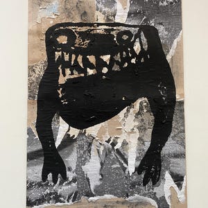 May include: Abstract artwork featuring a black creature-like figure with a wide mouth and two eye-like shapes. The figure is painted on a wood panel with torn paper collage elements in shades of gray, white, and tan.