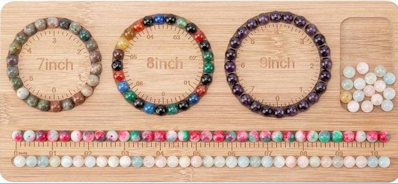 May include: A bamboo bead design board featuring three circular channels labeled 7inch, 8inch, and 9inch, each containing a beaded bracelet. The board includes a rectangular compartment with loose beads and two long horizontal channels filled with beads.