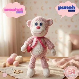 Op de afbeelding: Een handgemaakte roze gehaakte apenpop met witte accenten, blauwe ogen en een rood hartvormig accessoire. De afbeelding bevat de tekst "Crochet Pattern" en "punch Monkey". Garenballen en een schaar zijn op de achtergrond te zien.