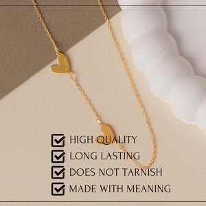 May include: A gold-colored chain necklace featuring two small heart-shaped charms, each engraved with a name. The image includes the text: HIGH QUALITY, LONG LASTING, DOES NOT TARNISH, MADE WITH MEANING, accompanied by four checkmark icons.