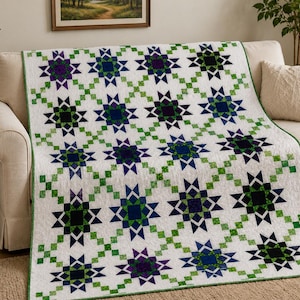 May include: A quilt featuring a repeating pattern of eight-pointed stars in shades of dark blue, purple, and green, set against a white background. The stars are connected by a lattice of small green squares, with a thin green border edge.