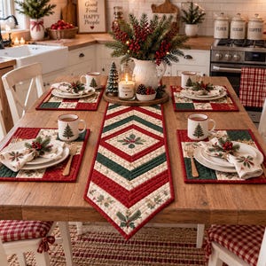 Puede incluir: Un camino de mesa acolchado y cuatro manteles individuales a juego con un patrón geométrico en rojo, verde oscuro y crema con motivos de hojas de acebo. El conjunto está dispuesto sobre una mesa de madera con tazas, platos y servilletas.