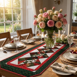 May include: A rectangular fabric table runner featuring a patchwork design of red, green, and white holiday-themed patterns. The runner is centered on a wooden dining table with place settings, a glass vase of pink roses, and white candles.