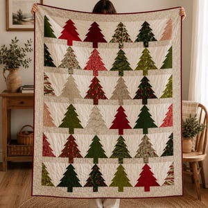 May include: A rectangular quilt featuring a repeating pattern of stylized Christmas trees in various shades of red, green, and neutral tones. The trees are arranged in rows against a cream-colored background, finished with a dark red border.