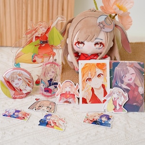 Könnte beinhalten: Eine Sammlung von Anime-Merchandise mit einem Charakter mit orangefarbenen Haaren und roten Augen. Artikel umfassen ein Plüschtier, Acryl-Aufsteller, Aufkleber, einen Button und einen Schlüsselanhänger. Die Farbpalette wird von Rot-, Orange- und Brauntönen dominiert.