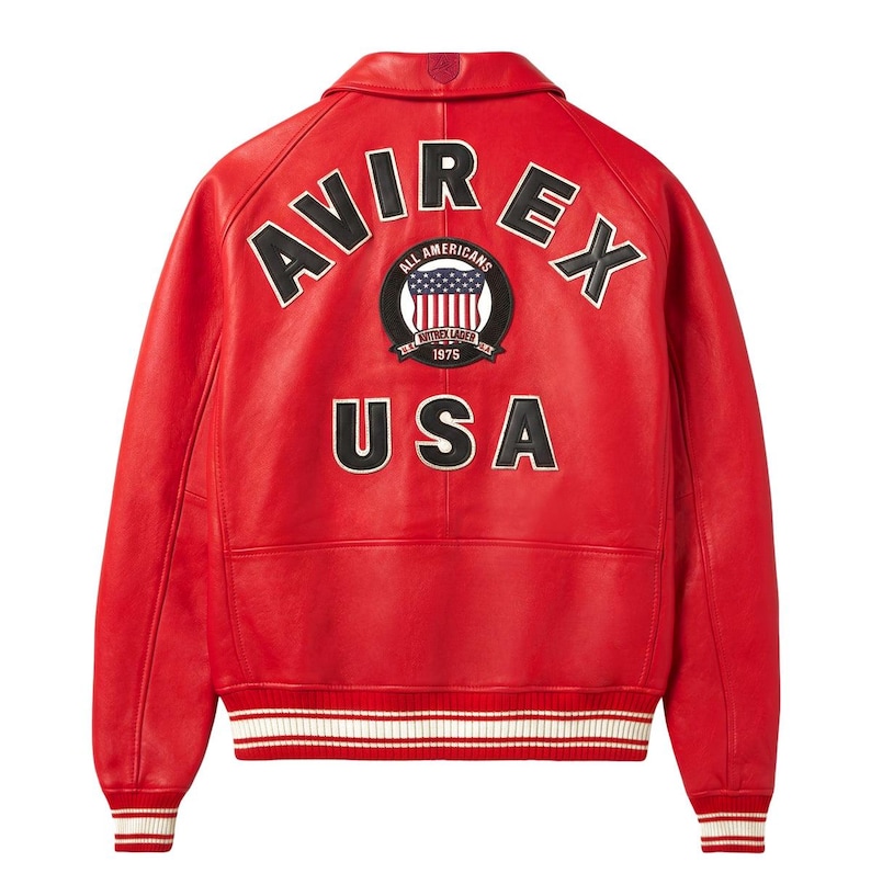 May include: A bright red leather jacket featuring a ribbed collar, cuffs, and hem with white stripes. The back displays the black text AVIR EX, a circular patch with a USA flag and the text ALL AMERICANS AVITREX LAGER 1975, and the text USA.