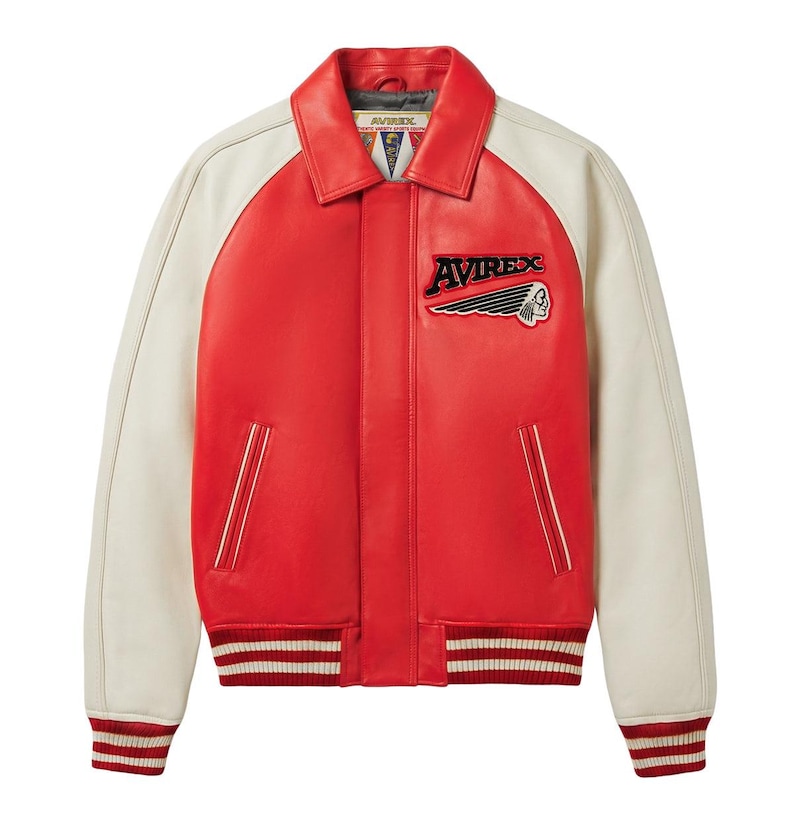 May include: A red and off-white varsity jacket featuring a classic collar, long sleeves, and a front button closure. The chest displays an embroidered Avirex logo with a graphic of a profile head. The cuffs and hem have red and white stripes.