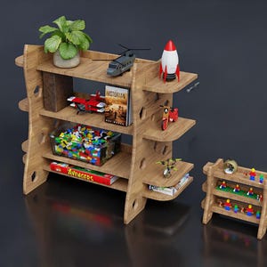 May include: A wooden shelf unit with multiple shelves, holding a potted plant, toy vehicles, books, and a container of colorful building blocks. A smaller matching shelf unit is also present.