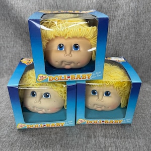 May include: A set of three ceramic mugs with a speckled, matte finish. The mugs are in shades of cream, light gray, and dark gray. Each mug has a simple, minimalist design, perfect for coffee or tea.