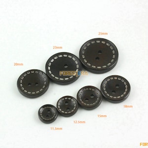 May include: Assortment of brown wooden buttons with white stitching around the edges. The buttons are in various sizes, ranging from 11.5 mm to 25 mm in diameter.