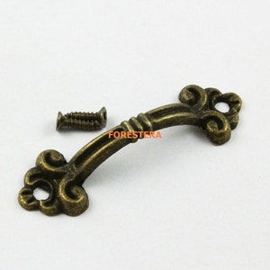 May include: Antique bronze cabinet pull with a decorative scroll design and two screws.