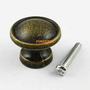 Op de afbeelding: Antiek messing kastknop met een ronde bovenkant en een schroef. De knop heeft een verweerde afwerking.