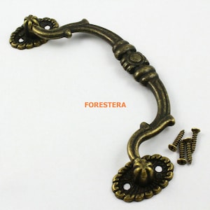 May include: Antique-style bronze cabinet pull with ornate details and a curved design. The pull comes with screws for installation.
