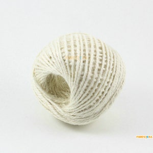 May include: A ball of natural twine made from jute fibre. The twine is a light cream colour and is wound tightly into a ball shape.