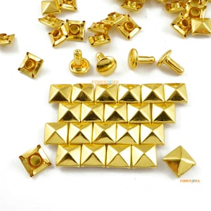 Peut inclure: Un ensemble de clous pyramidaux dorés à base carrée. Les clous sont disposés en rangées et sont prêts à être utilisés pour des projets d'artisanat.