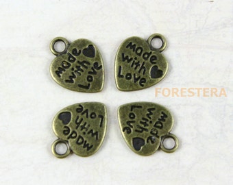 May include: Four antique gold heart-shaped charms with the text "Made with Love" in black lettering.
