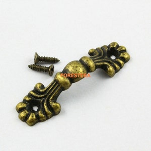 May include: Antique brass cabinet pull with ornate design and two screws.