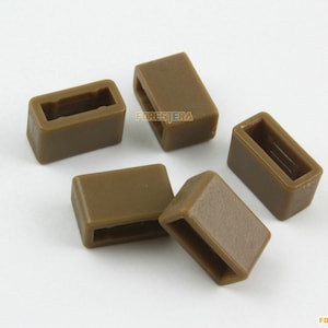 May include: Five brown plastic rectangular-shaped cable end caps with a rectangular opening in the center.