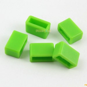 May include: Five bright green plastic slider buckles. The buckles are rectangular with a small opening on each side.