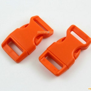May include: Two bright orange plastic side release buckles. The buckles are designed for use with webbing or straps.
