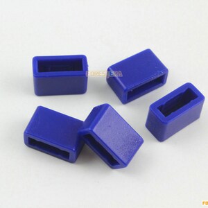 May include: Five blue plastic buckle keepers. The buckle keepers are rectangular with a small opening in the center.