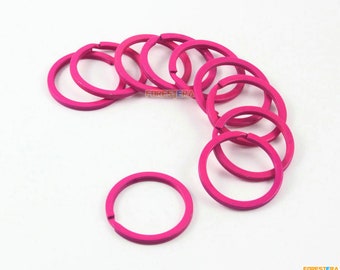 Può includere: Dieci portachiavi in metallo rosa, disposti a semicerchio, con un portachiavi separato dal gruppo.